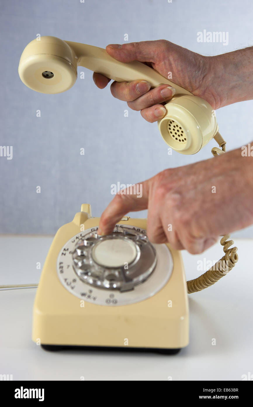 Dialing a number on an old fashioned rotary dial telephone Stock Photo