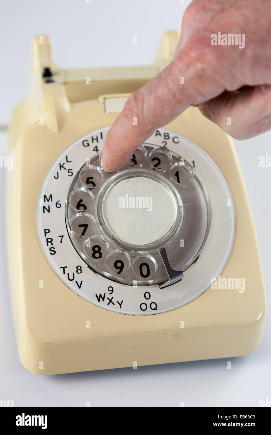 Dialing a number on an old fashioned rotary dial telephone Stock Photo