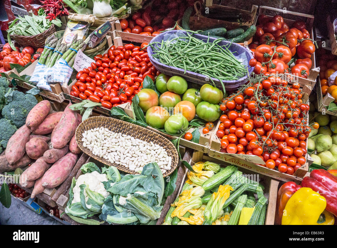 colorful sidewalk display of snap peas beans squash flowers cauliflower tomatoes etc outside shop selling fresh produce Florence Stock Photo