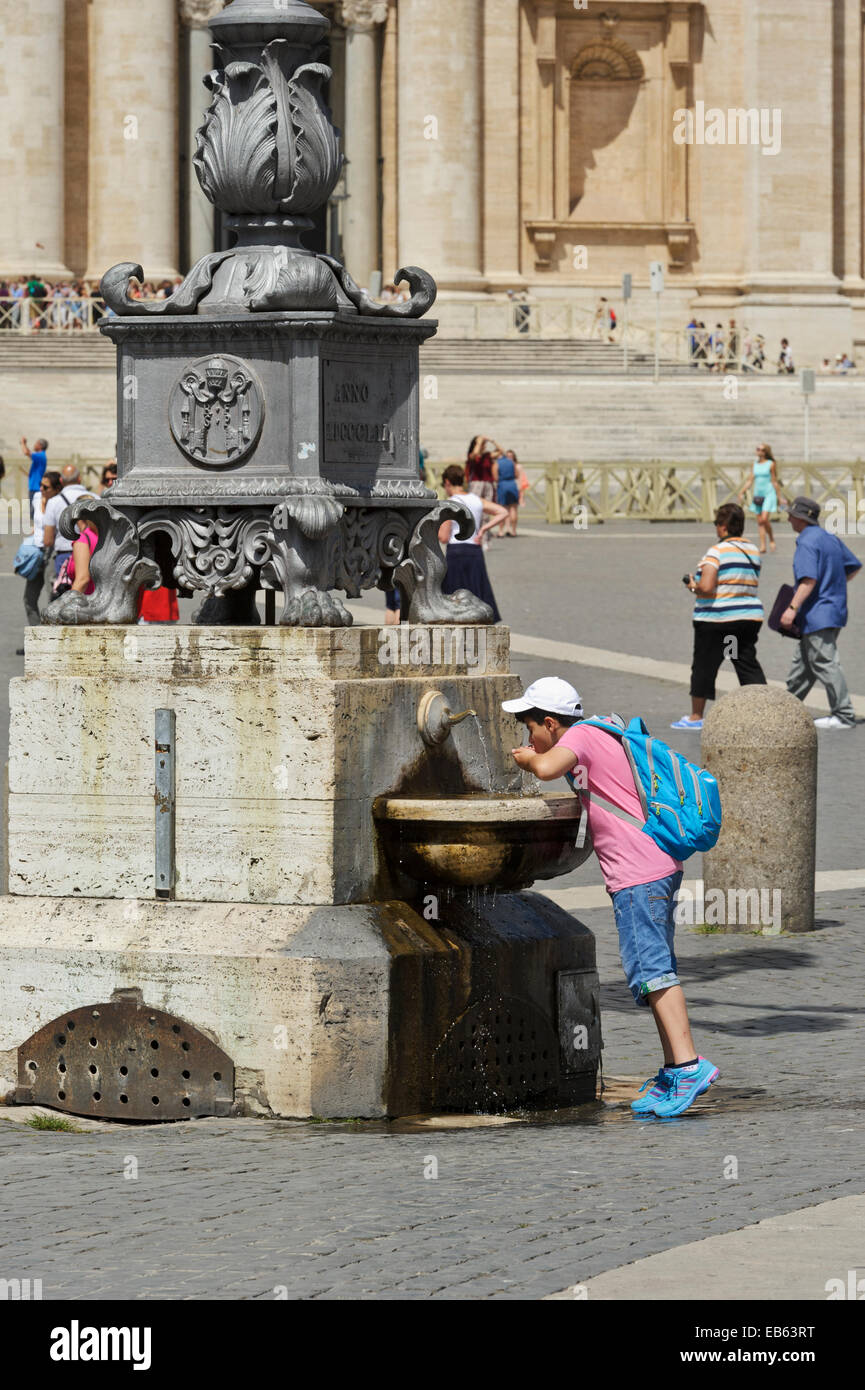 A young boy drinking water from a fountain in the square in Vatican City in Rome, Italy Stock A young boy drinking water from a fountain in the square in Vatican City in Rome, Italy Stock