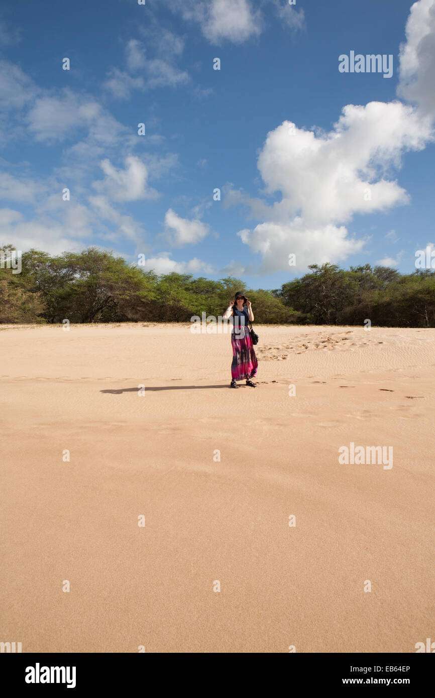 Women on the Beach holding her hat in the Wind Stock Photo