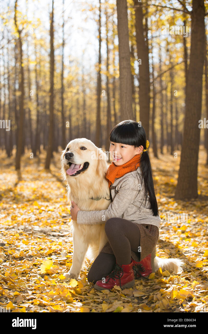 Little girl playing with dog in autumn woods Stock Photo - Alamy