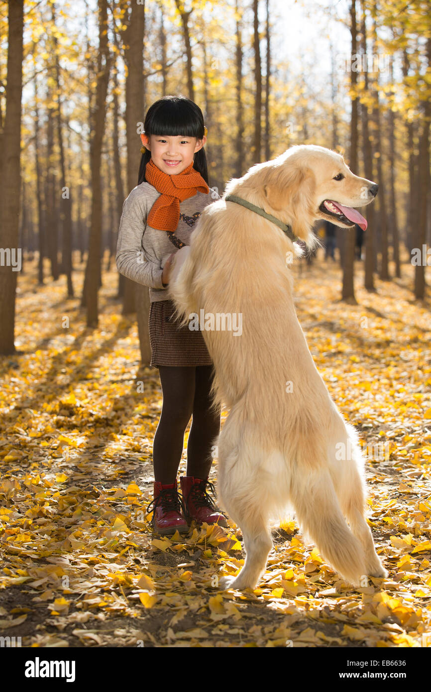 Little girl playing with dog in autumn woods Stock Photo - Alamy