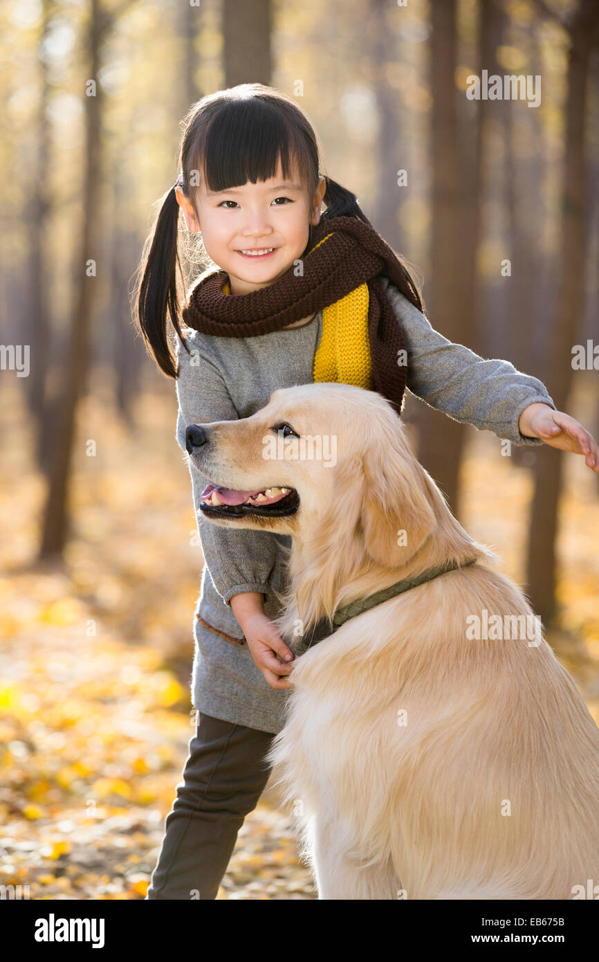 Little girl playing with dog in autumn woods Stock Photo - Alamy