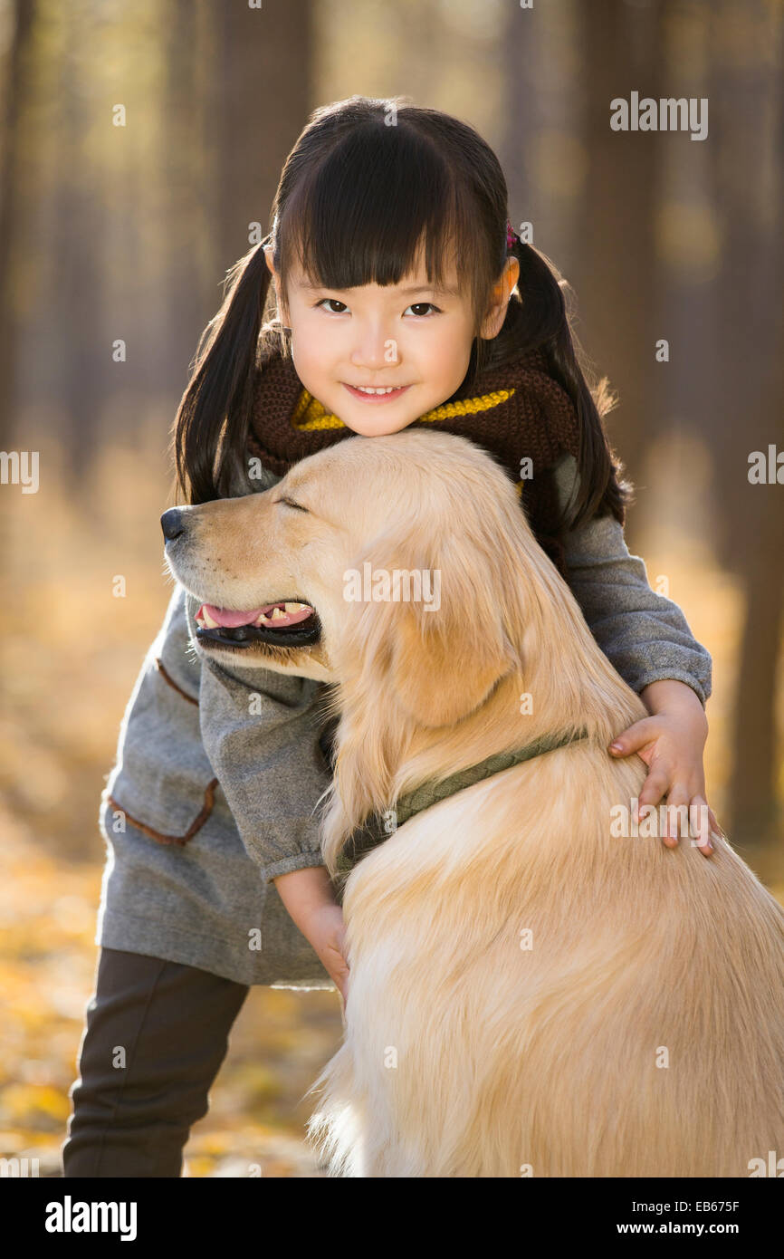 Little girl playing with dog in autumn woods Stock Photo - Alamy
