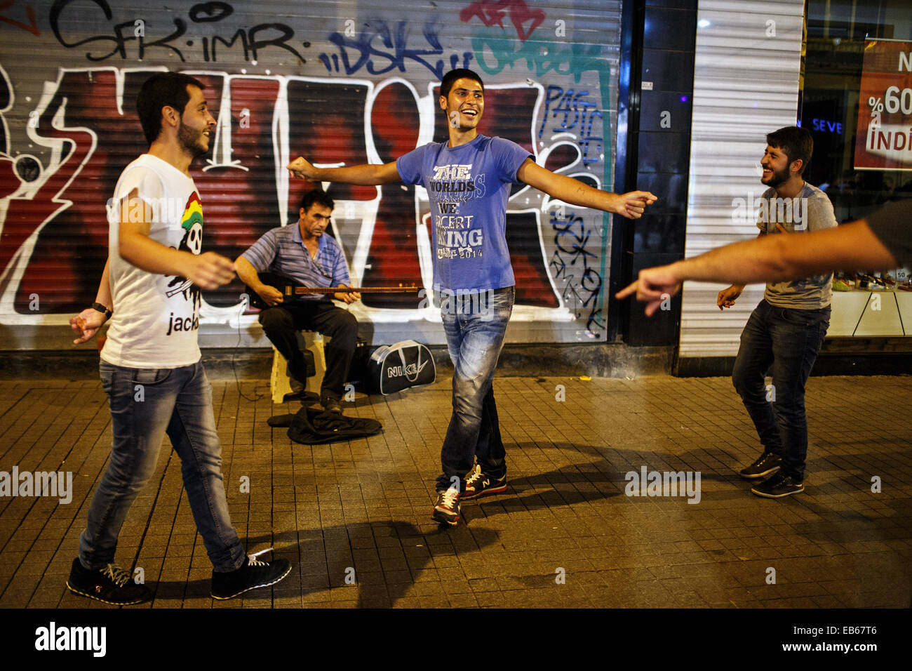 Young men dance on the street on a weekend night on Istiklal Caddesi, Beyoglu, Istanbul, Turkey. Stock Photo