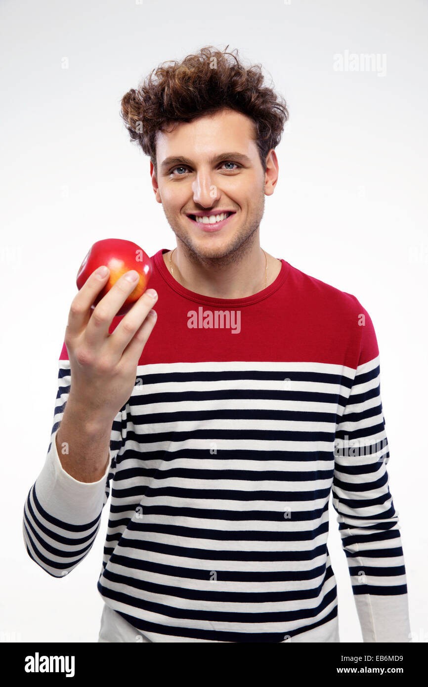 Smiling man holding red apple over gray background Stock Photo - Alamy