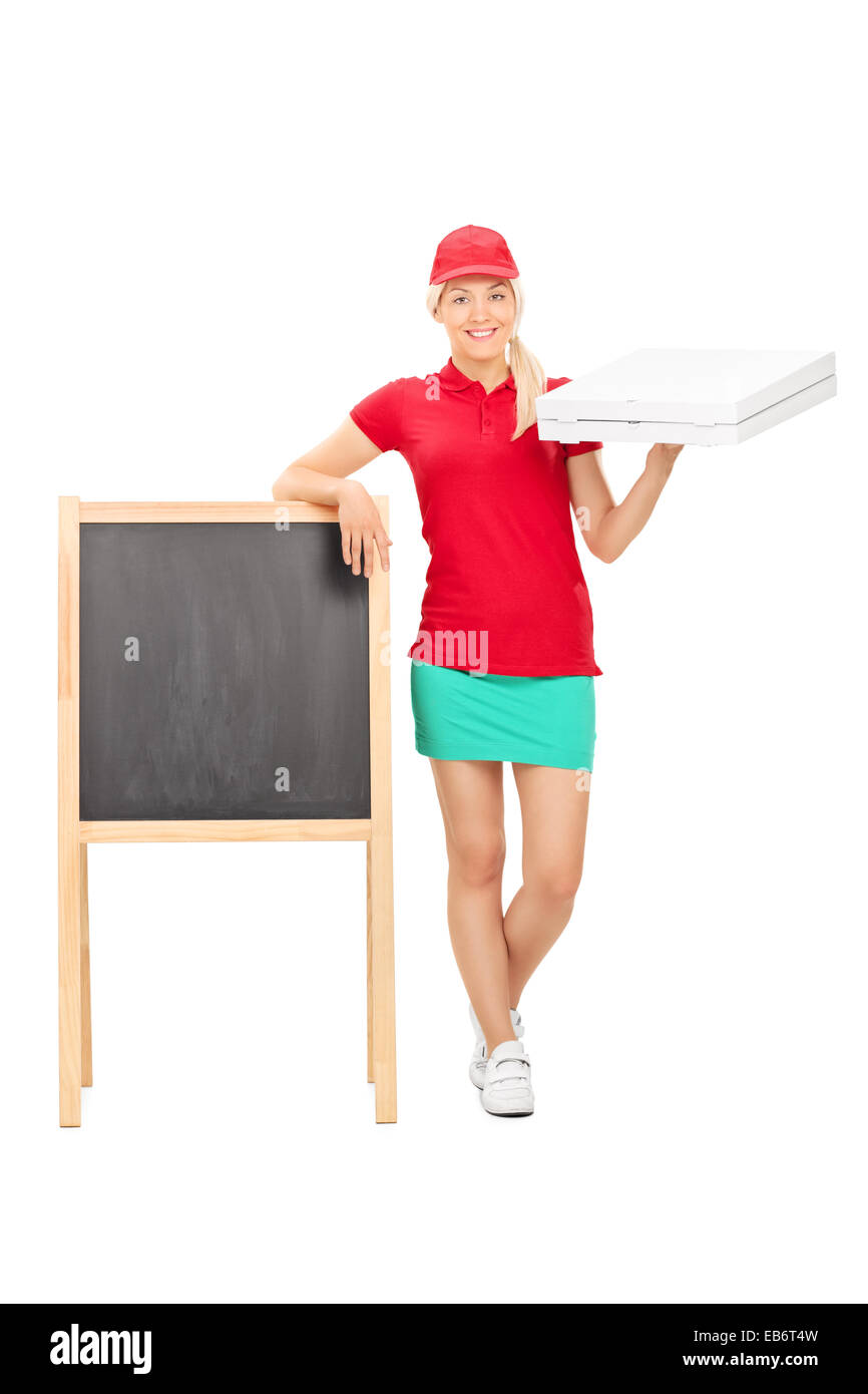 Full length portrait of a pizza delivery girl standing by a blank blackboard isolated on white background Stock Photo
