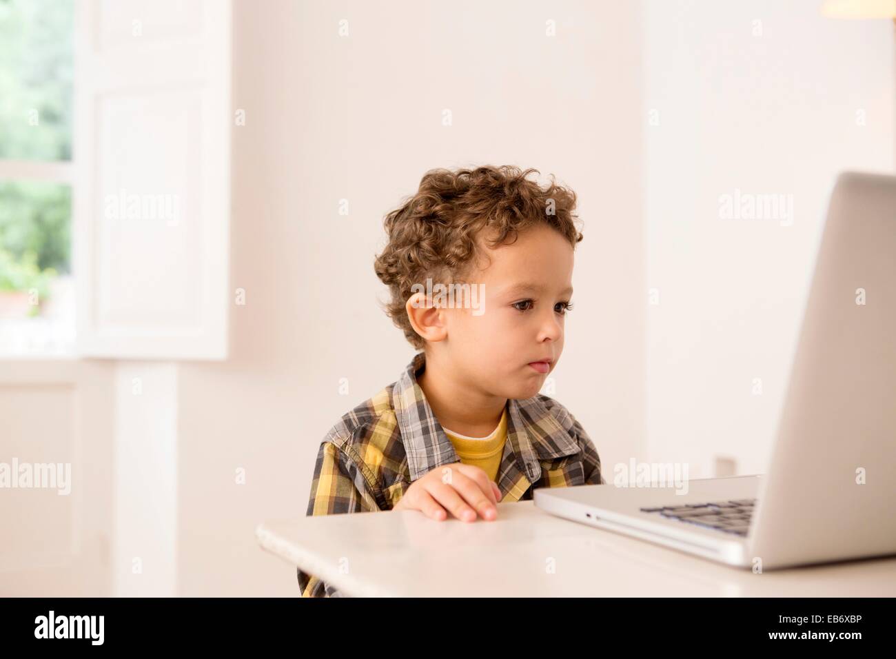 Four year old boy playing games on a laptop Stock Photo Alamy