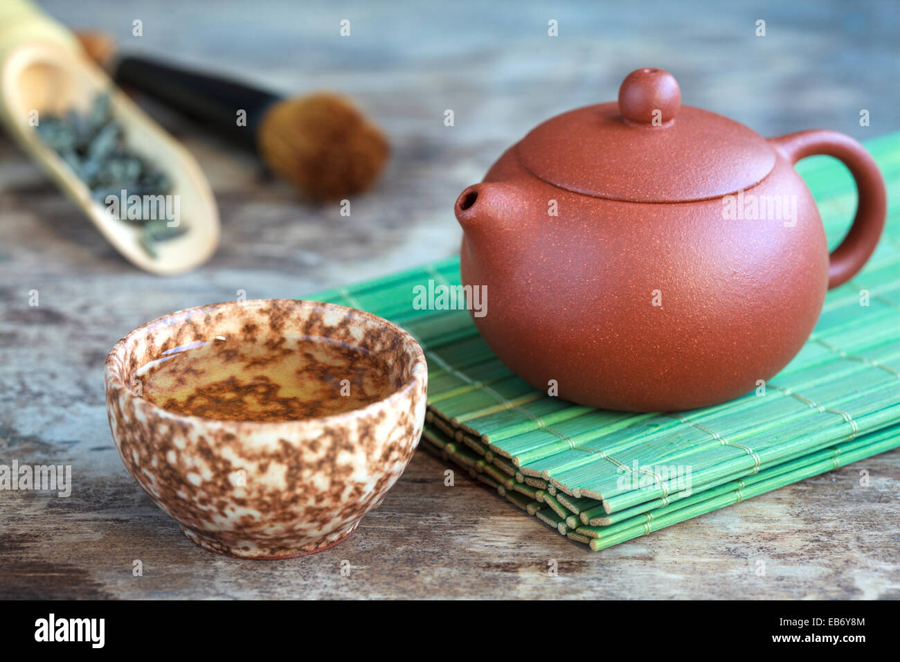 Traditional chinese tea ceremony accessories: tea pot, cup and green tea on  the wooden table, selective focus on pot Stock Photo - Alamy