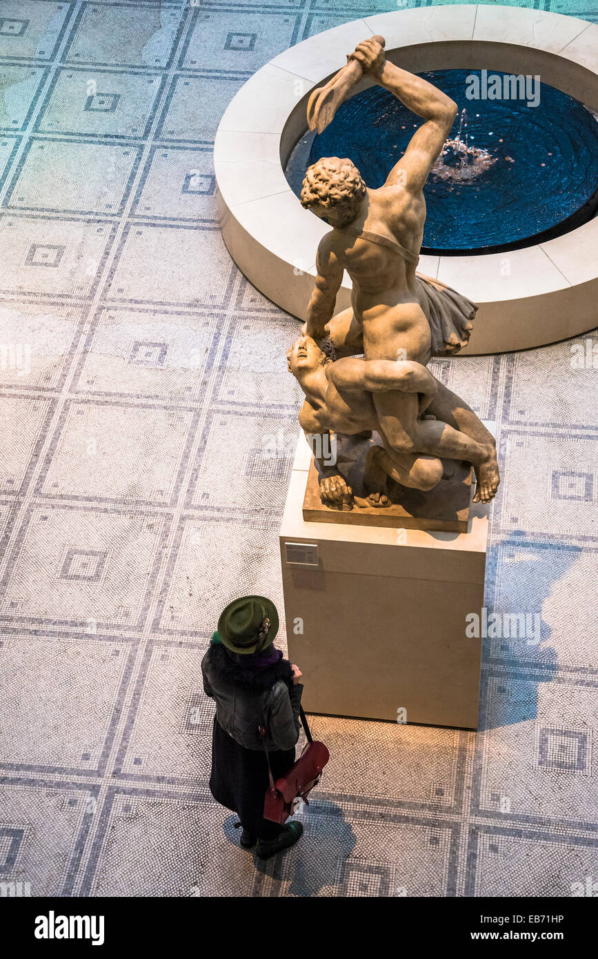 Woman looking at 16th century Italian sculpture of Samson Slaying a