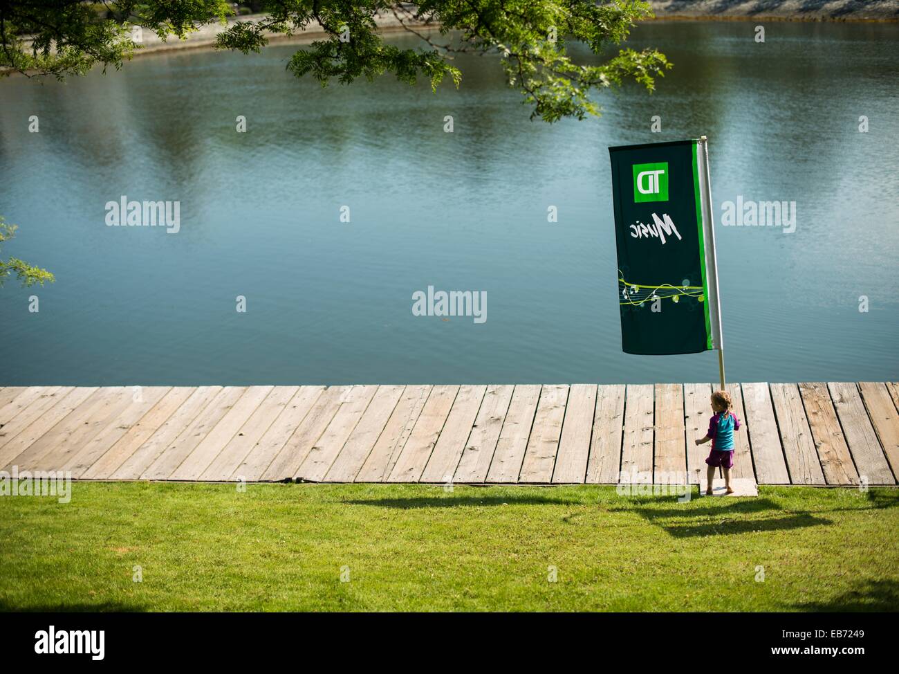 A Child On The Boardwalk By A Banner Of The Jazz Festival At The