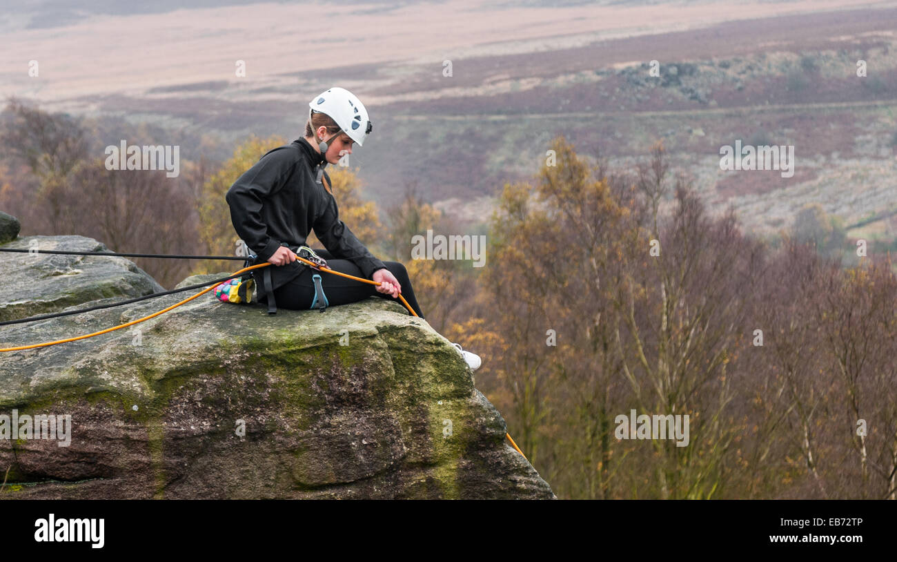 Young teenage girl rock climbing on Birchen Edge in The Peak District of Derbyshire Stock Photo
