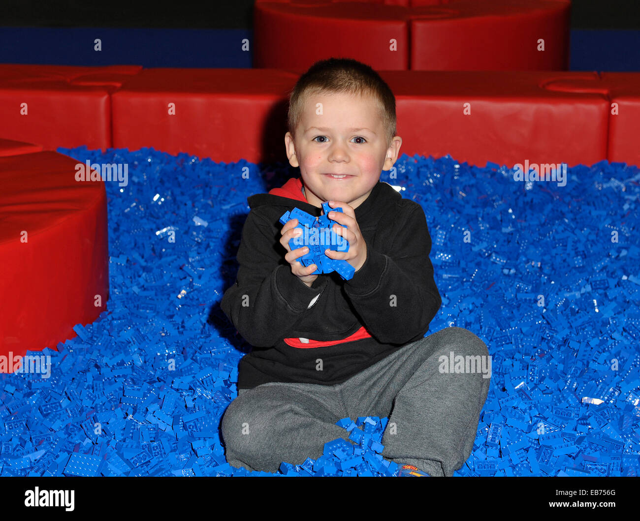 LEGO.  Leonard, aged 3 from Maidstone in Kent enjoys himself playing in a pit of blue LEGO bricks. Stock Photo