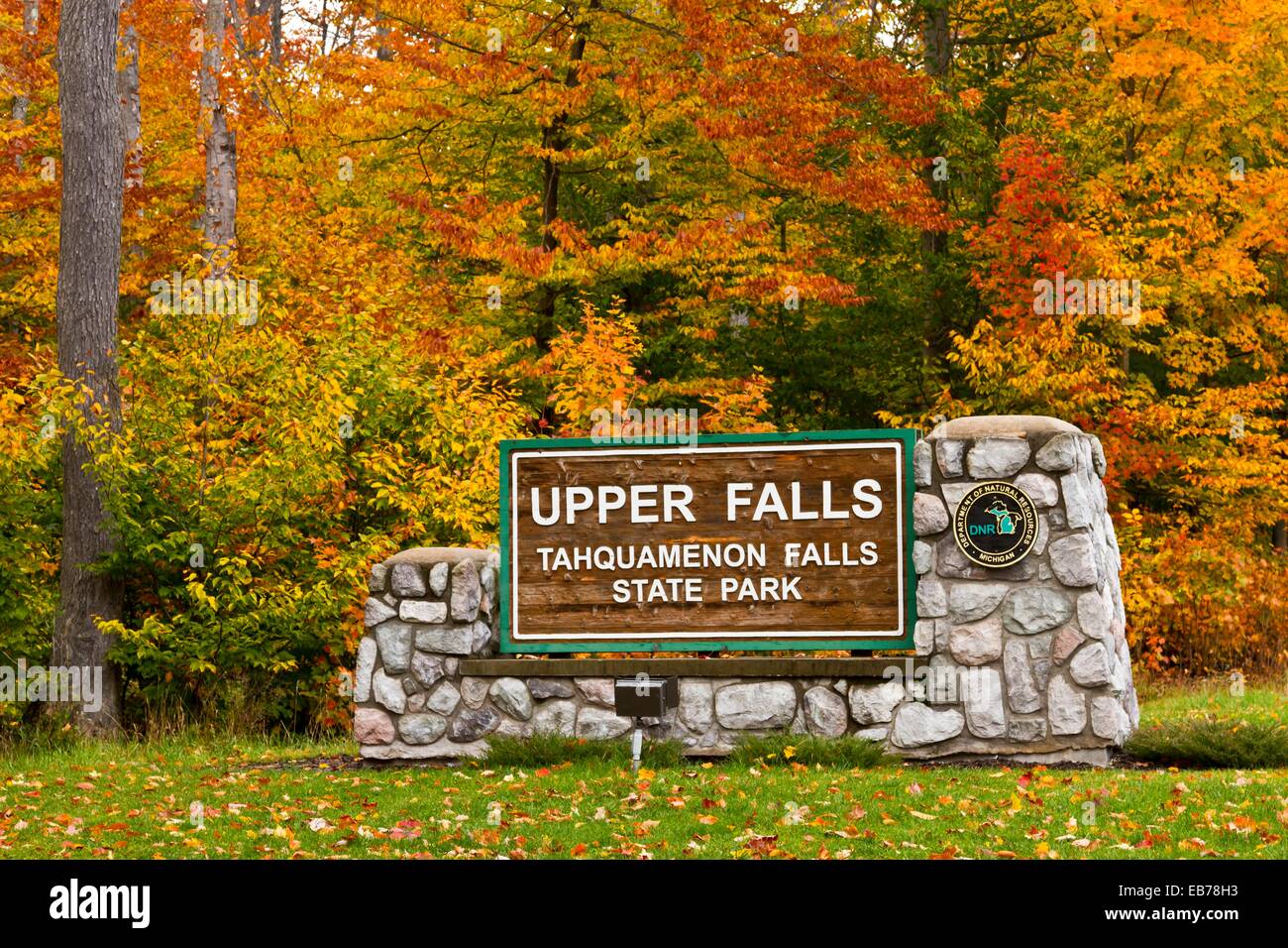 The Upper Tahquamenon Falls sign with fall foliage color near Newberry