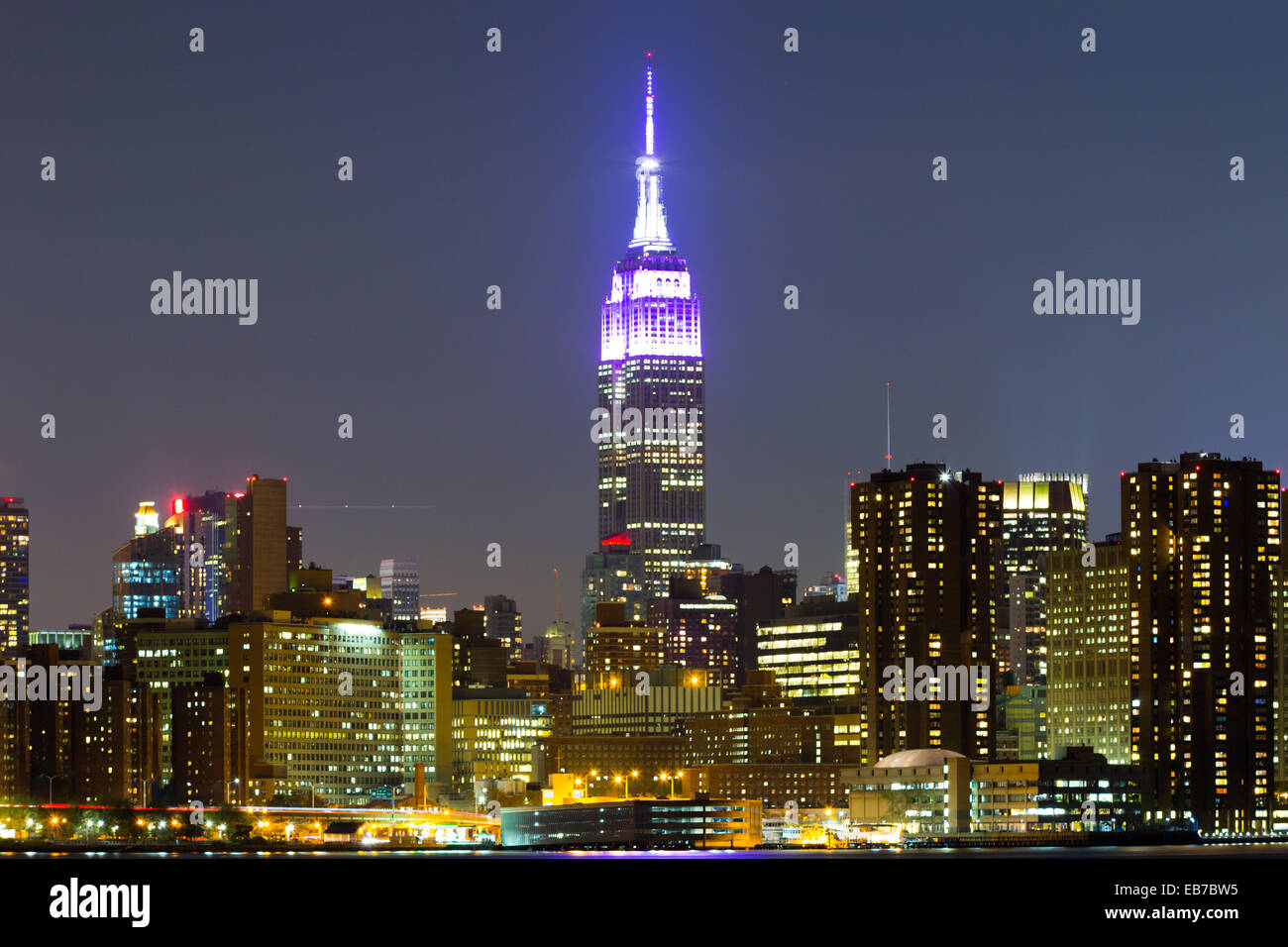 Manhattan'S Empire State Building with skyline and East River by night