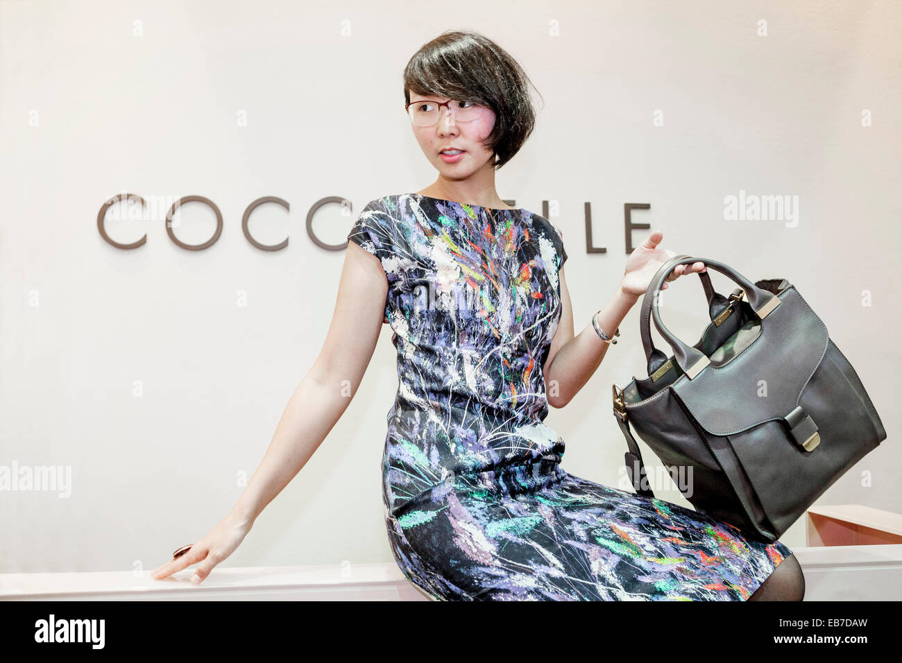 Young Asian woman with a handbag Coccinelle Stock Photo