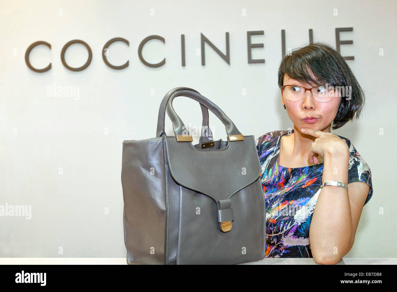 Young Asian woman with a handbag Coccinelle Stock Photo