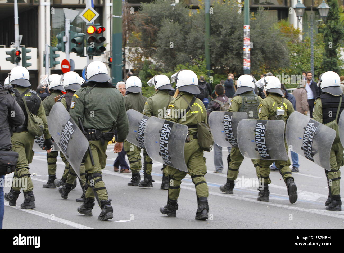 Athens, Greece. 27th November 2014. Greek riot police officers follow the protest march. Tens of thousands Greeks followed the call by Greek Trade Union for a one day general strike and protest march to the Greek parliament. They protested against the austerity measures by the Greek government. Credit:  Michael Debets/Alamy Live News Stock Photo