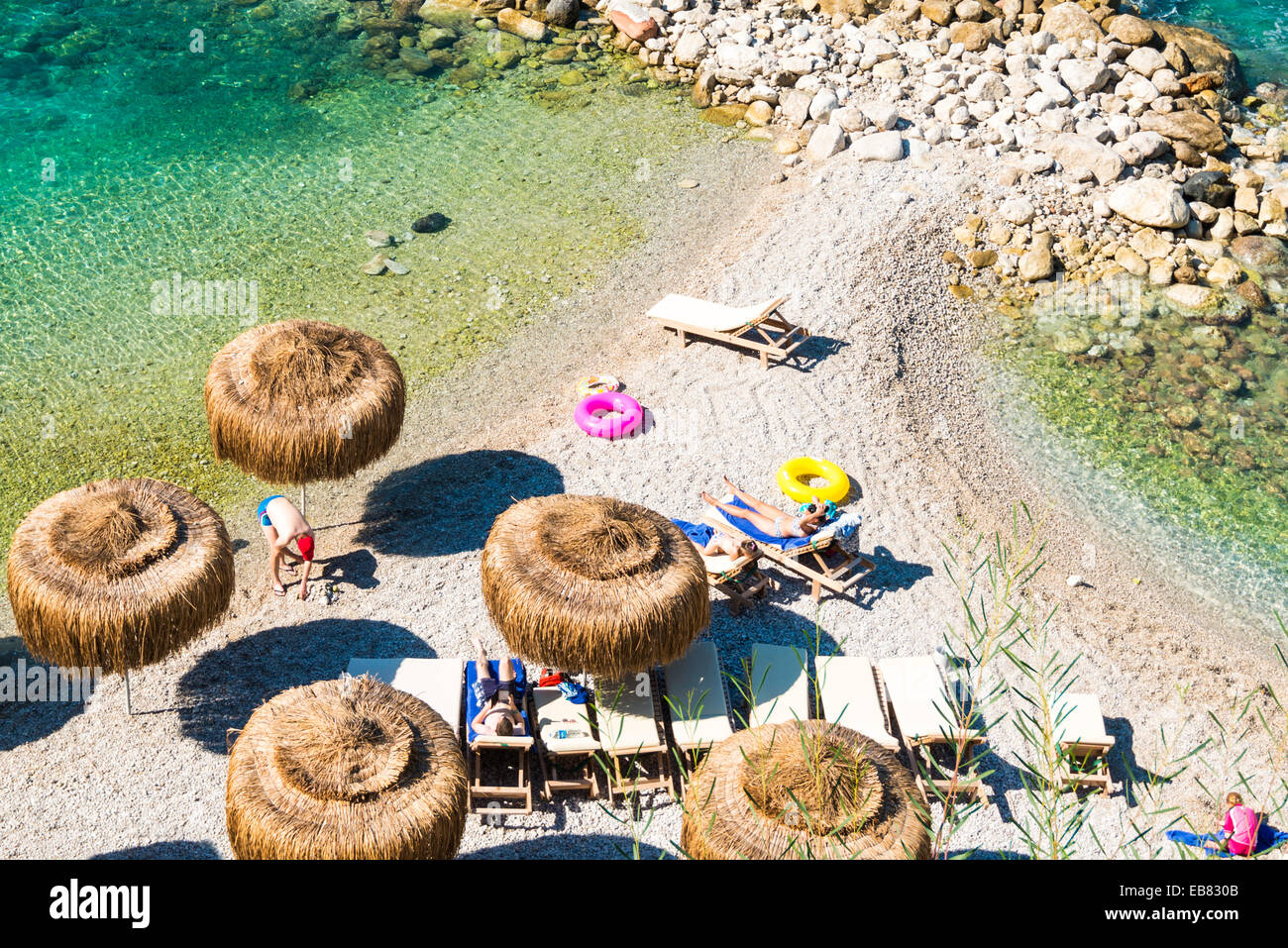 OELUEDENIZ, TURKEY - OCTOBER 20, 2014: People at the beach with sunbeds and parasols seen from above in the luxurious holiday re Stock Photo