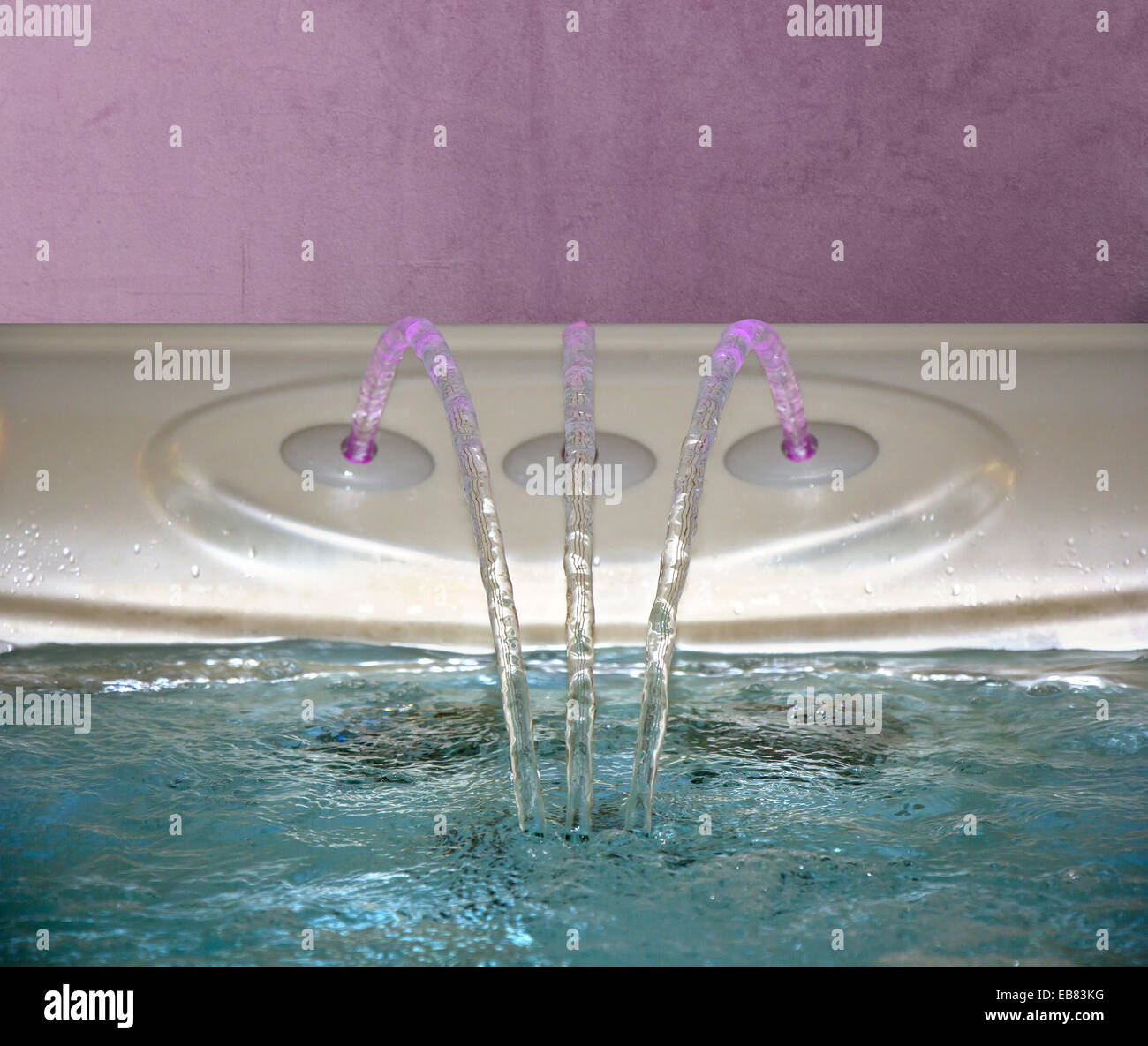 Jacuzzi Bathtub filling up with clean water from a three faucet Stock