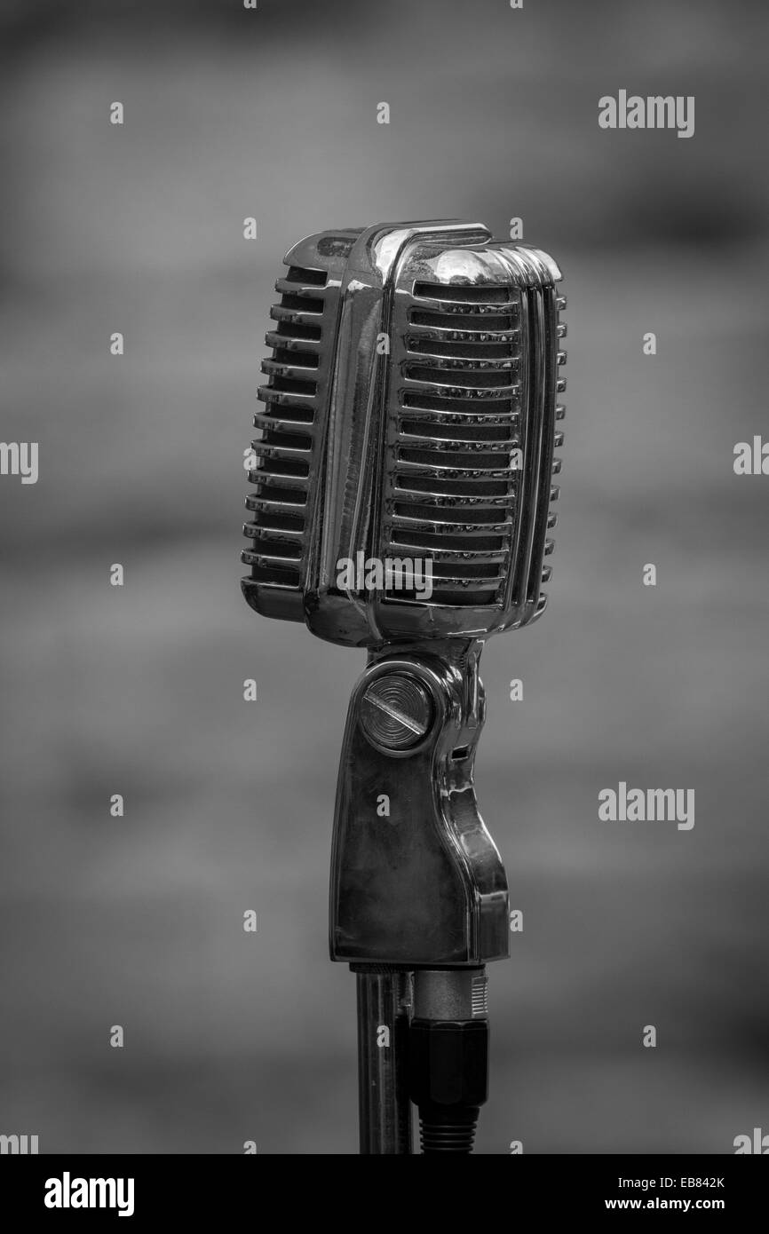 A close up upright black and white photograph of an early microphone from 1940s era against a plain background Stock Photo
