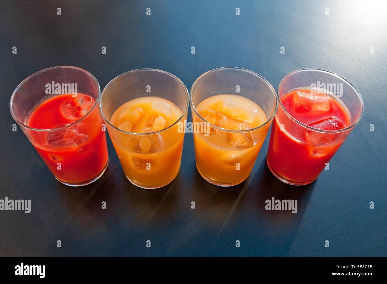 Four glasses of tomato and peach juice, composing Spanish flag Stock
