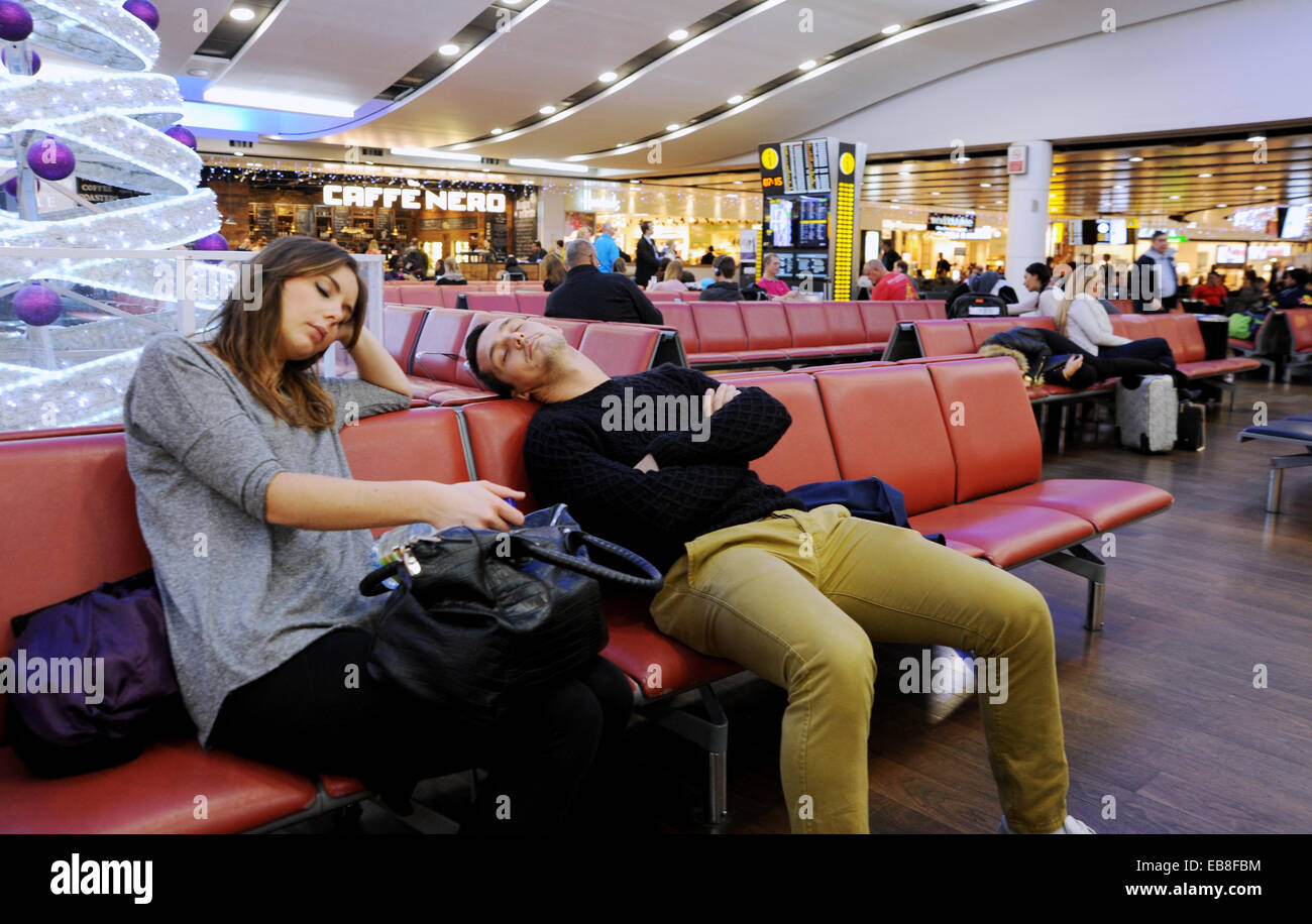 Heathrow Airport UK   - Couple asleep waiting in departure lounge of Terminal 3 at Heathrow London Airport Stock Photo