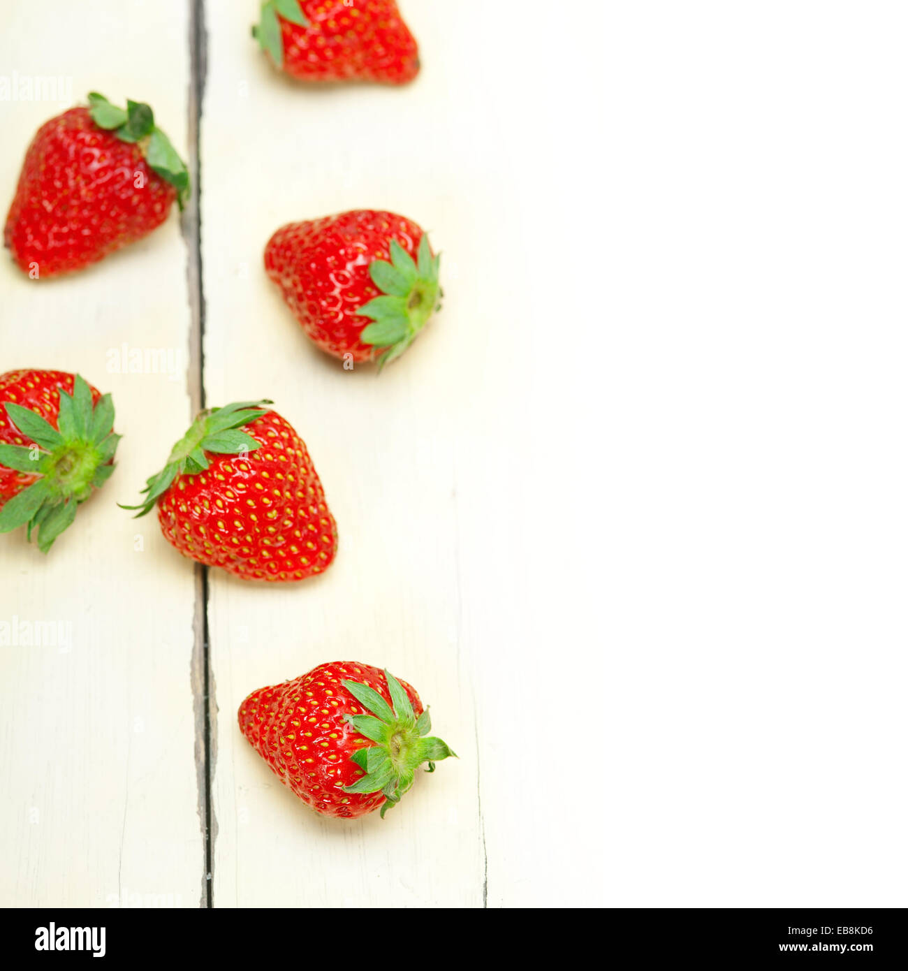 fresh organic strawberry over white rustic wood table Stock Photo - Alamy