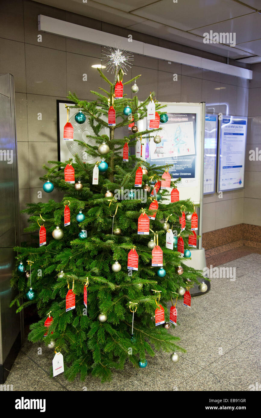 London, UK. 27 November 2014.  Christmas tree at Angel Tube Station. The Islington Christmas Tree Project launched by the Commissioner of the Metropolitian Police aims to provide Christmas presents to disadvantaged children/children in care in Islington. People interested in contributing can email islingtonxmastreeproject@met.pnn.police.uk and they will be allocated a child to buy a present for. Credit:  Nick Savage/Alamy Live News Stock Photo