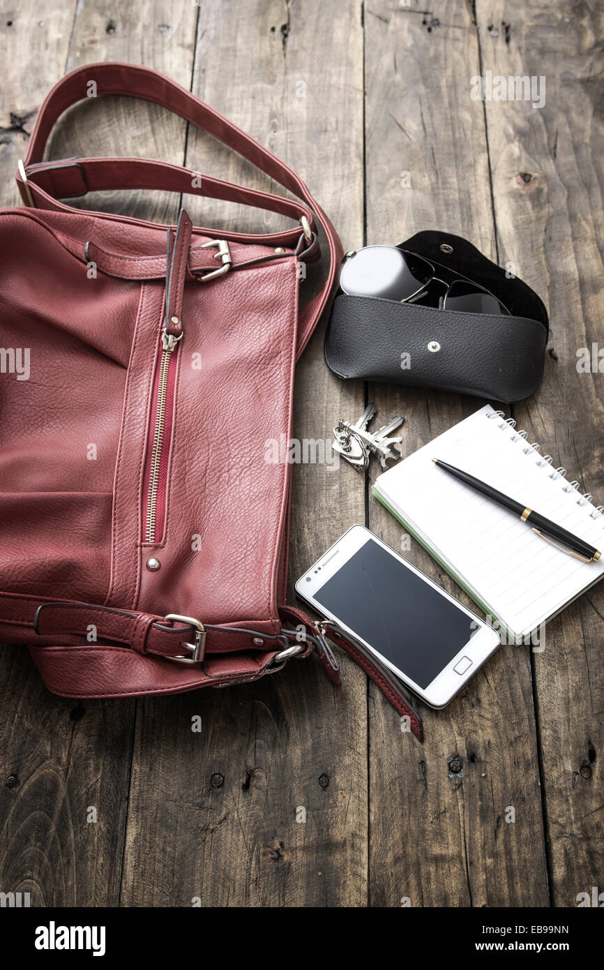 woman bag stuff, handbag over rustic wooden background Stock Photo