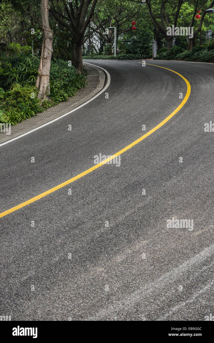 curved road with trees on both sides Stock Photo