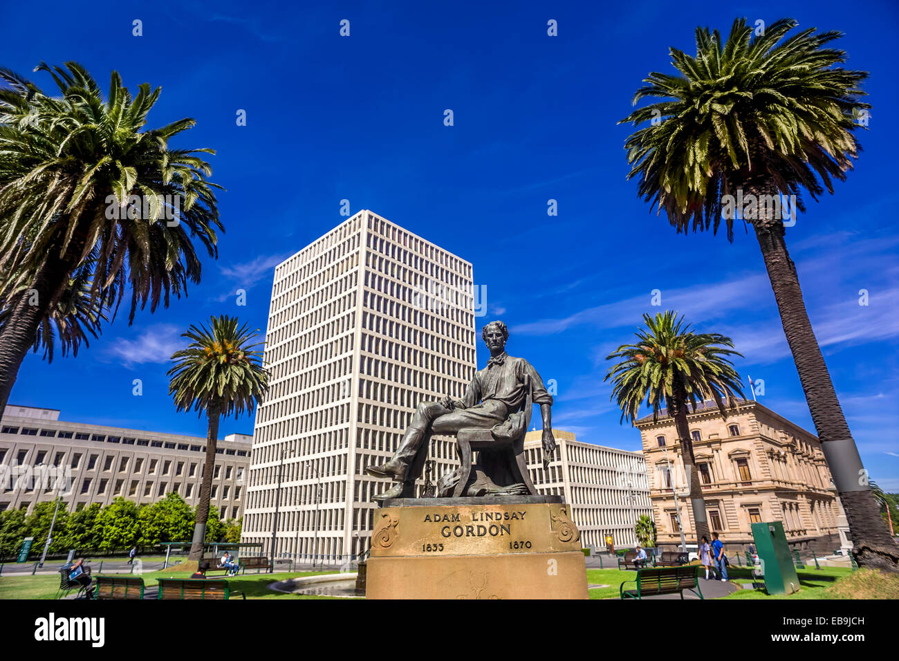 Bronze sculpture of Adam Lindsay Gorden, against Melbourne city with palm trees, Spring Street Melbourne Australia Stock Photo