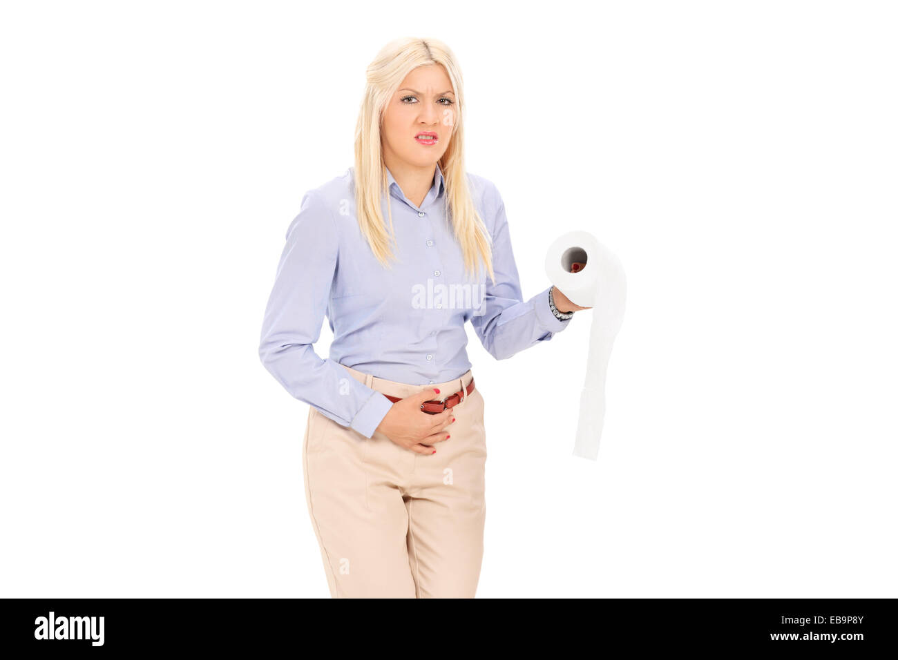 Young woman in need to pee holding a toilet paper isolated on white