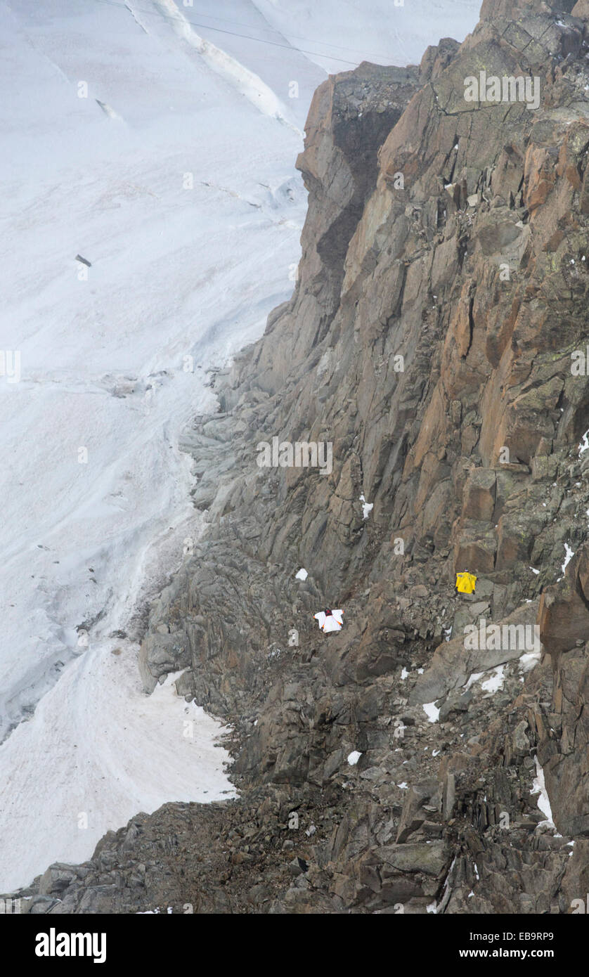 Base jumpers wearing wing suites jump from the Aiguille Du midi above Chamonix, France. Stock Photo