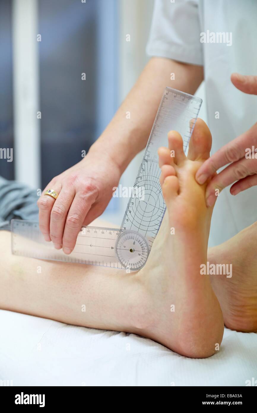Doctor with goniometer measuring ankle plantar flexion