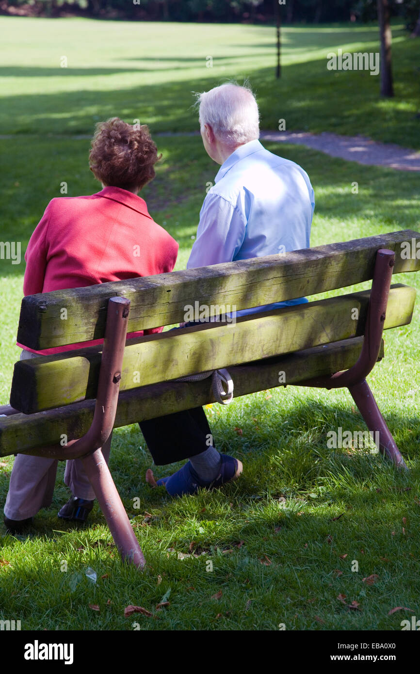 Older couple sitting on a park bench Stock Photo - Alamy