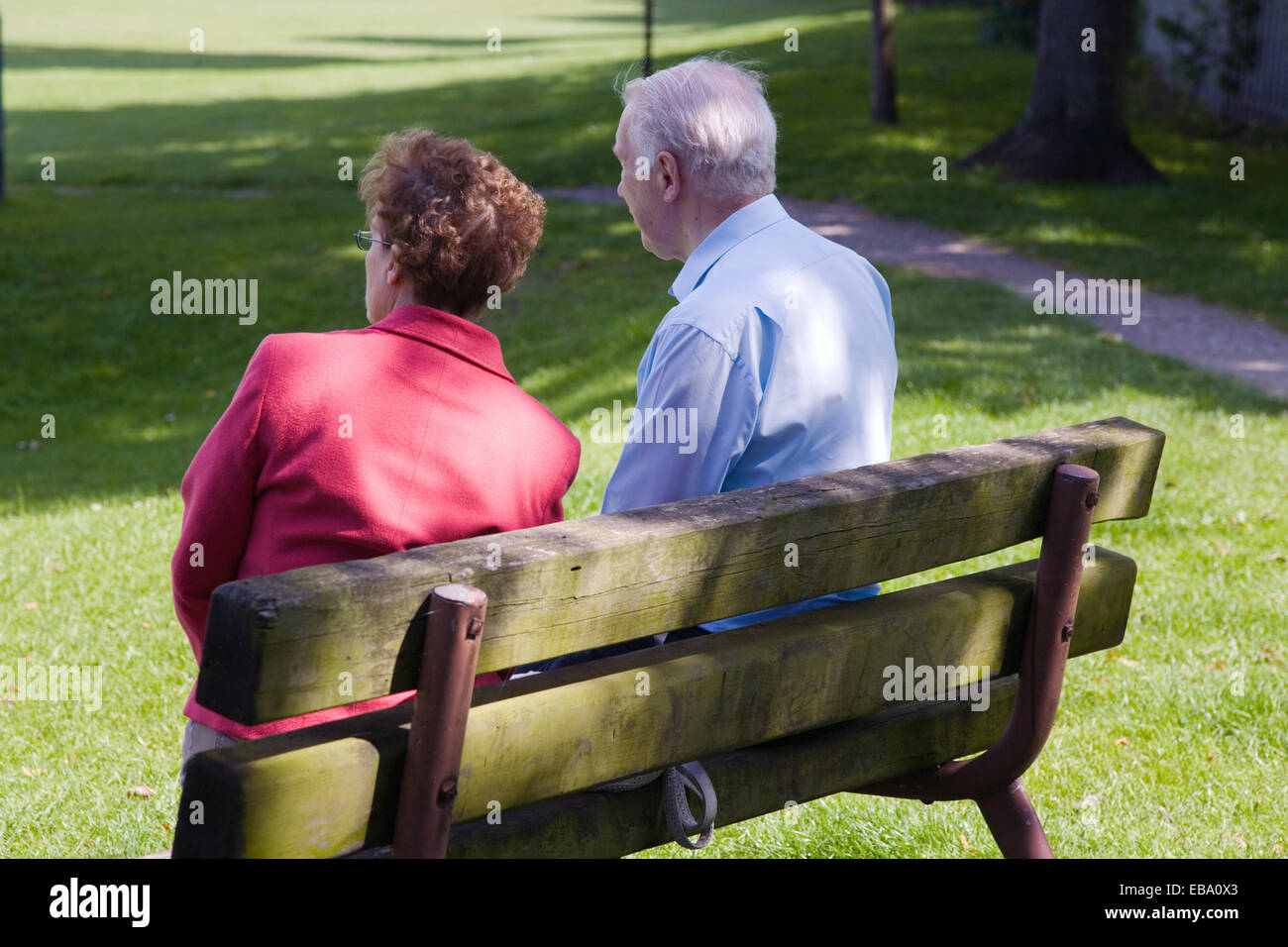 Older couple sitting on a park bench Stock Photo - Alamy