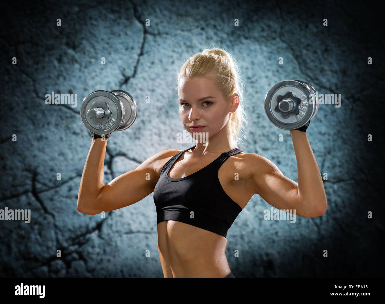 young sporty woman with dumbbells flexing biceps Stock Photo - Alamy