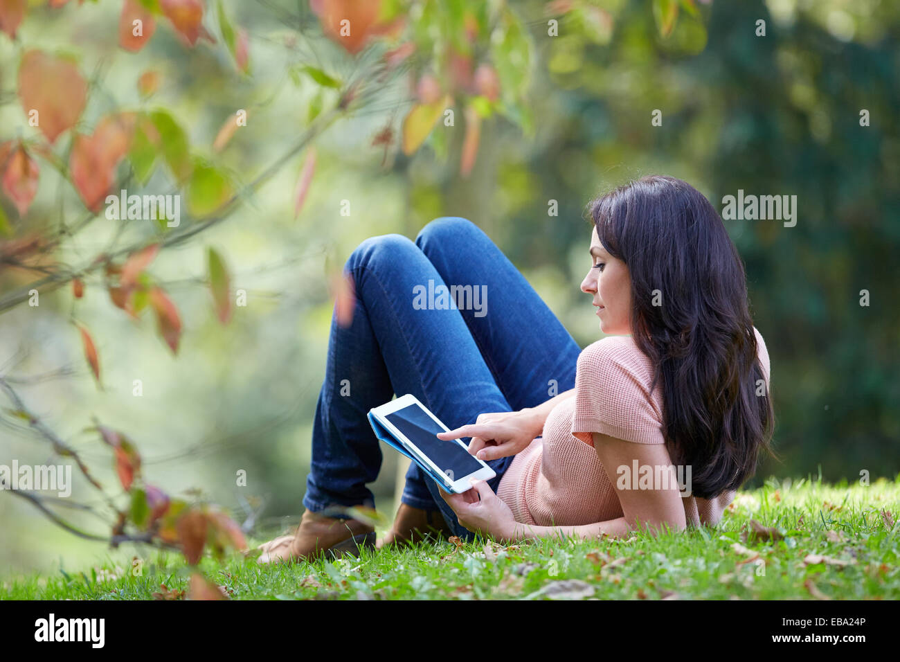35 year old woman with digital tablet in park. Donostia. San Sebastian. Gipuzkoa. Basque Country Spain. Stock Photo