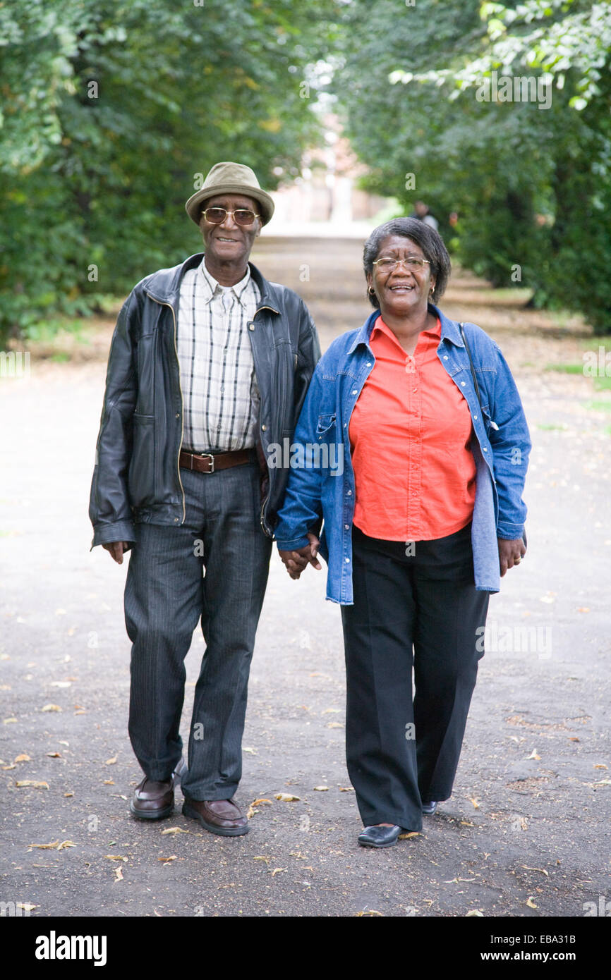 Older couple walking down an avenue of trees in the park together Stock ...