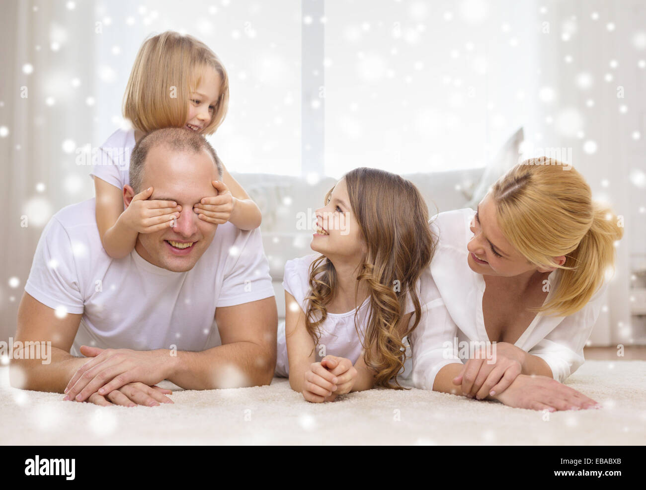 smiling parents and two little girls at home Stock Photo