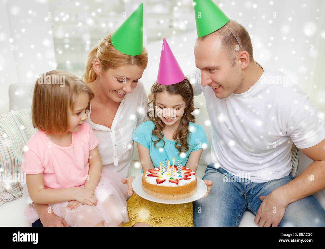 happy family with two kids in party hats at home Stock Photo