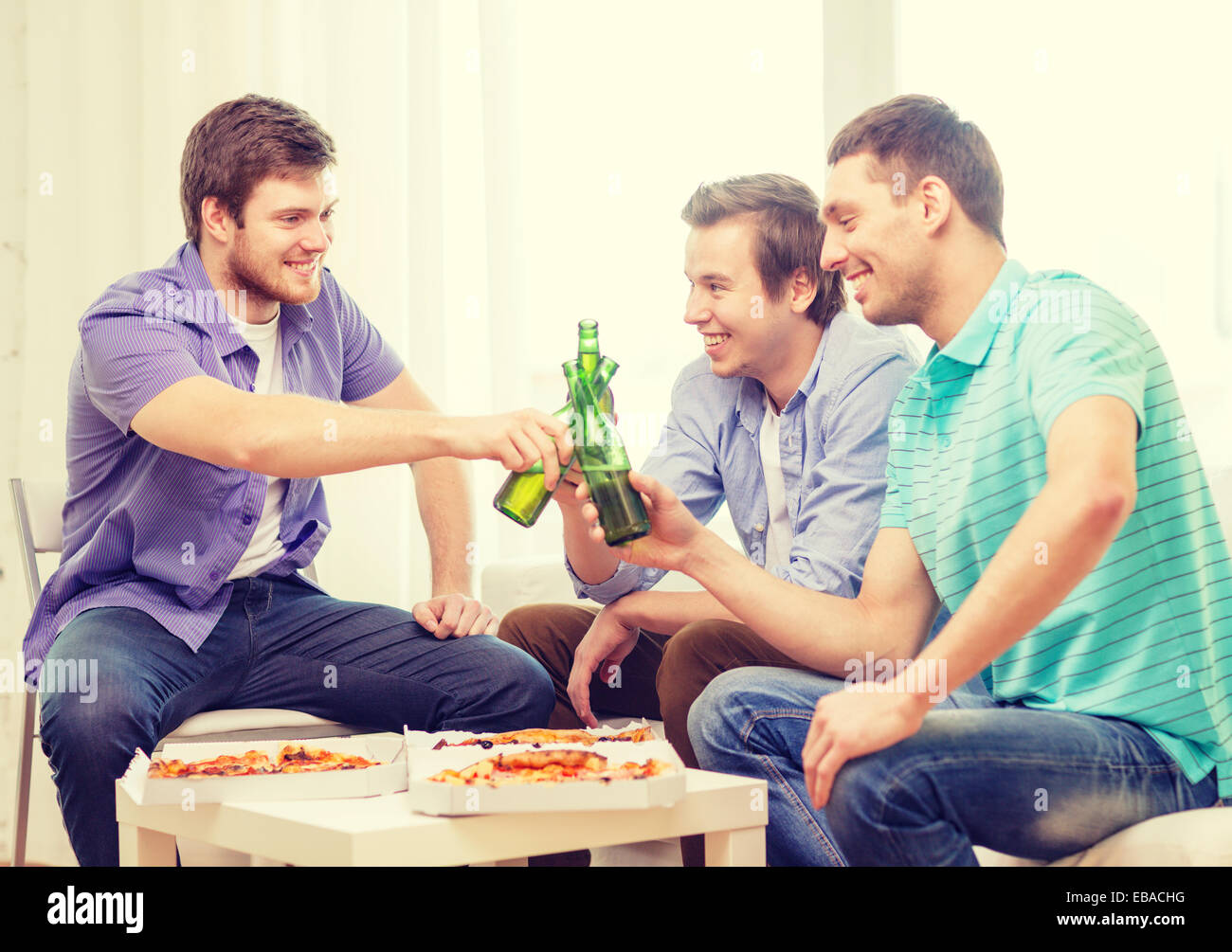 smiling friends with beer and pizza hanging out Stock Photo