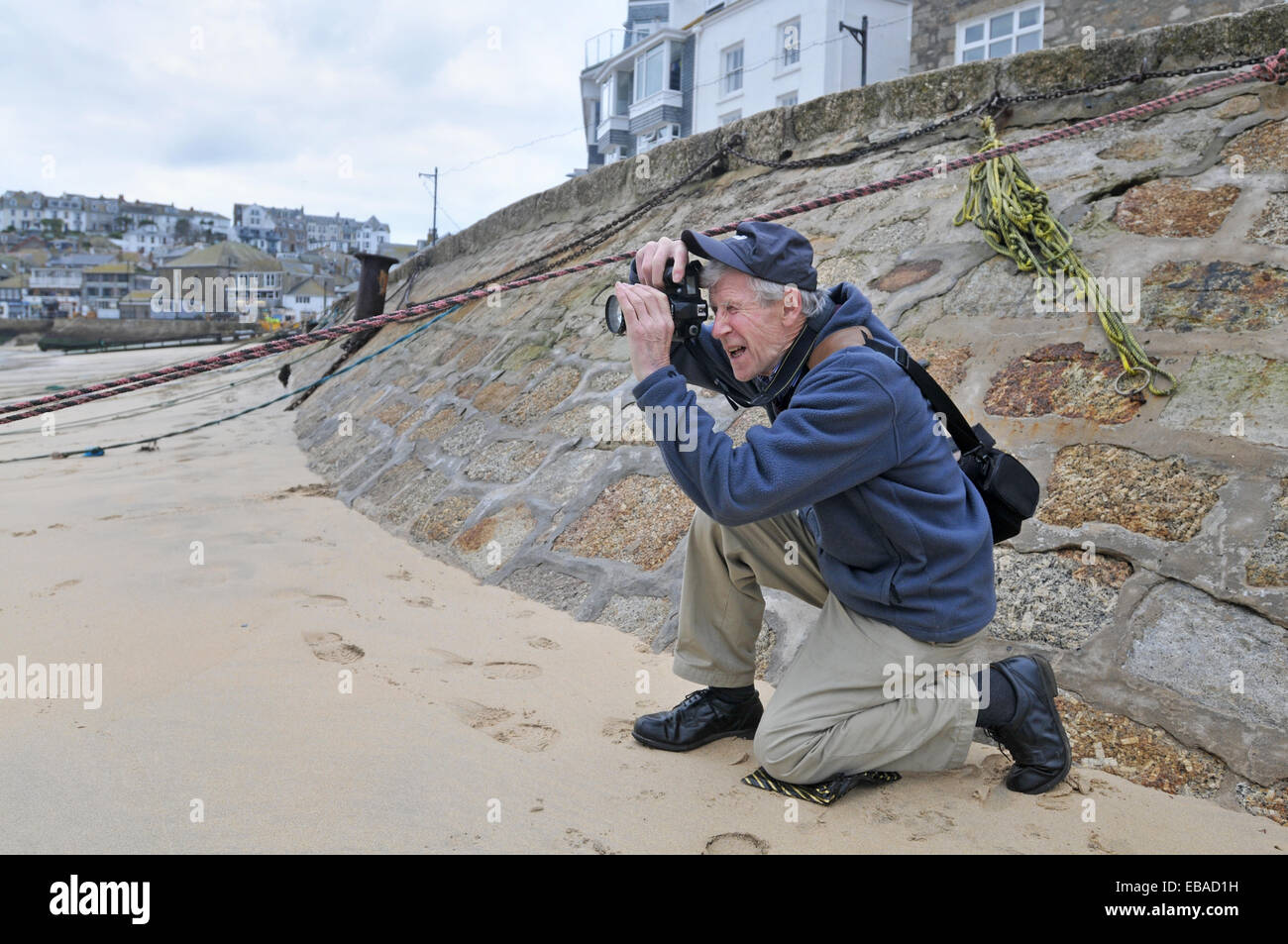 A retired man taking photographs on a beach Stock Photo