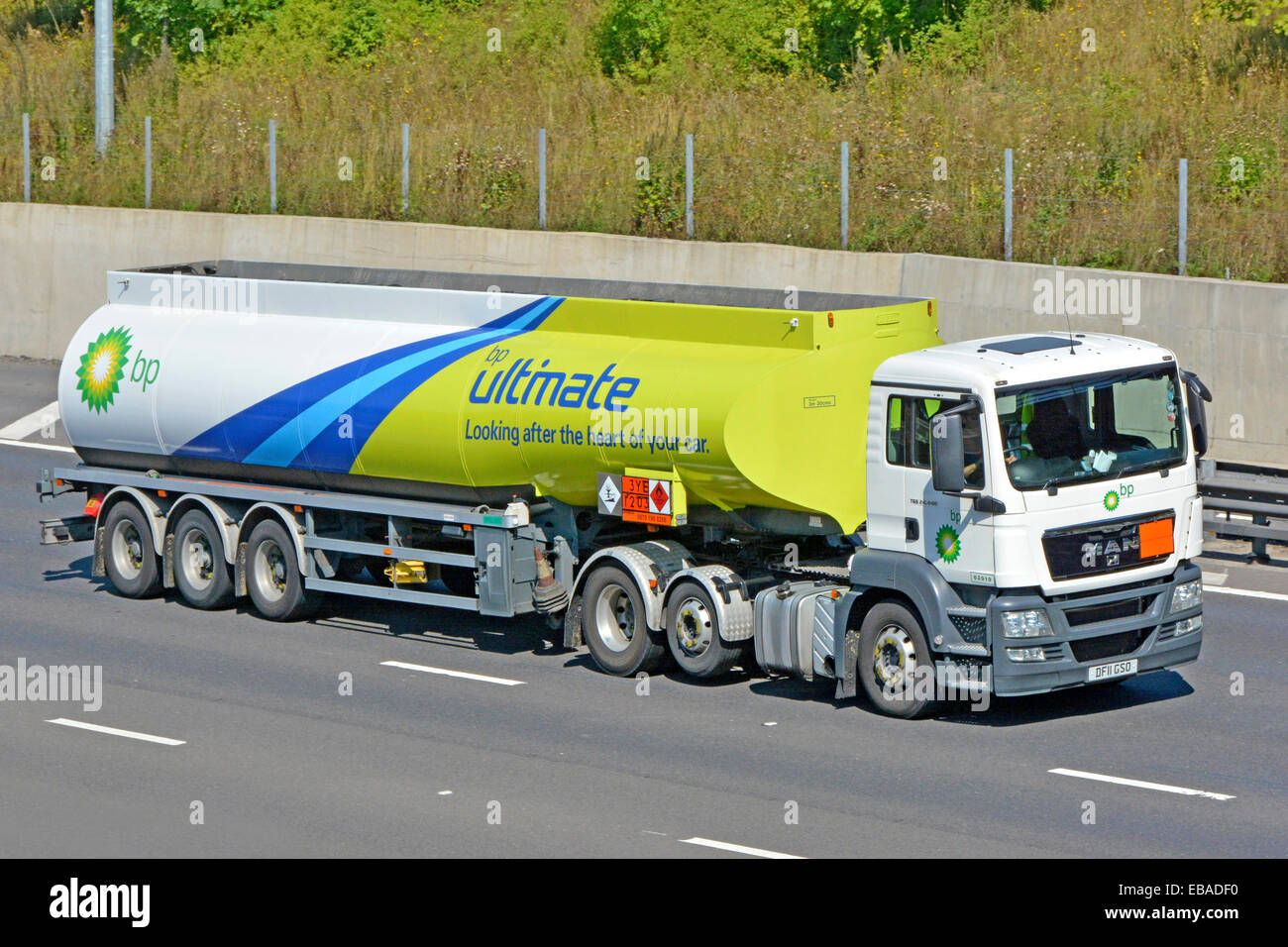 BP fuel delivery tanker trailer & MAN hgv lorry truck driving on M25 motorway & displaying Hazchem Hazardous Chemicals Dangerous Goods sign England UK Stock Photo