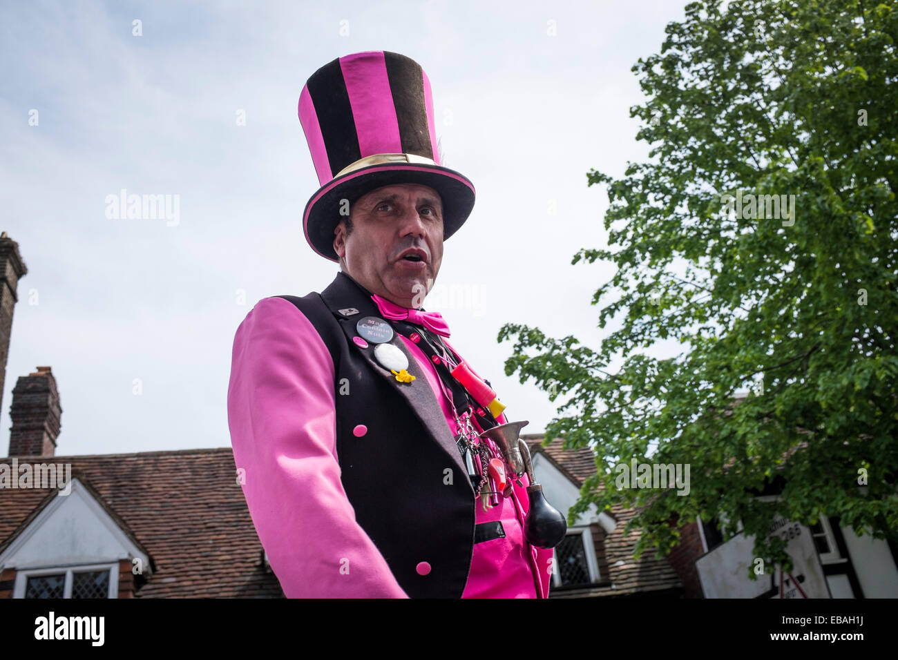 Close-up of a street entertainer on stilts, wearing bright clothes and a top hat at the Charter Fair in Haslemere. Stock Photo