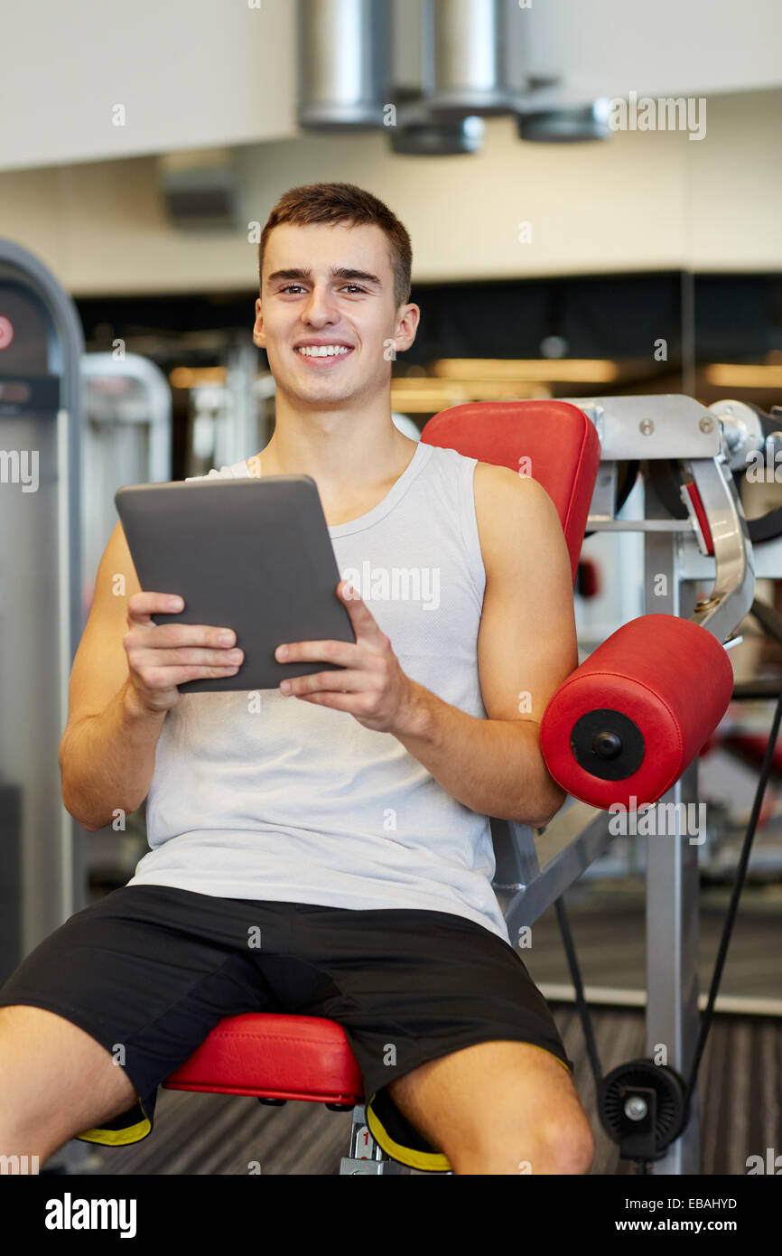 smiling young man with tablet pc computer in gym Stock Photo - Alamy