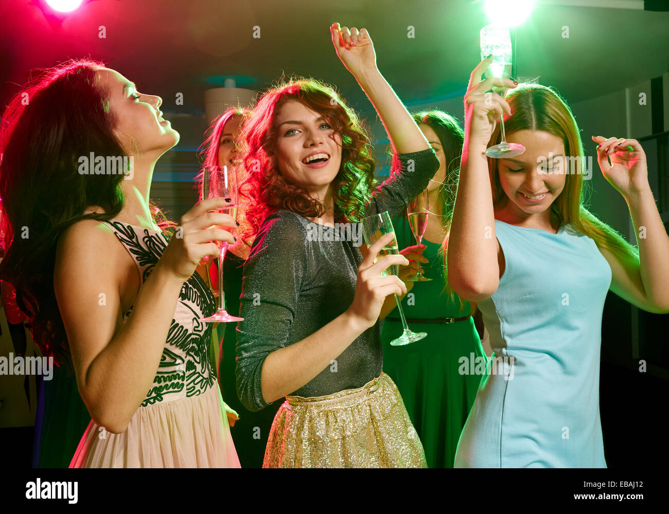 smiling friends with glasses of champagne in club Stock Photo