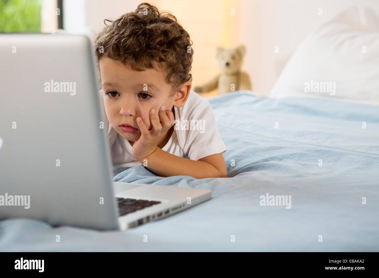 Four year old boy playing games on a laptop Stock Photo Alamy